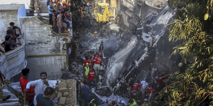Karachi: Volunteers look for survivors of a plane that crashed in a residential area of Karachi, Pakistan, May 22, 2020. An aviation official says a passenger plane belonging to state-run Pakistan International Airlines carrying more than 100 passengers and crew has crashed near the southern port city of Karachi. AP/PTI(AP22-05-2020_000271A)